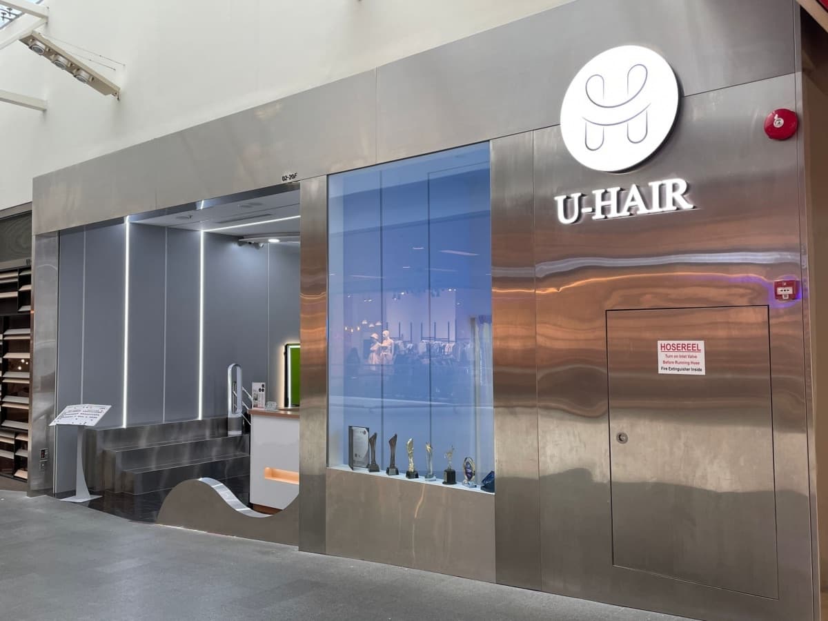 The U-Hair shopfront, brushed steel and stone with the house's mark